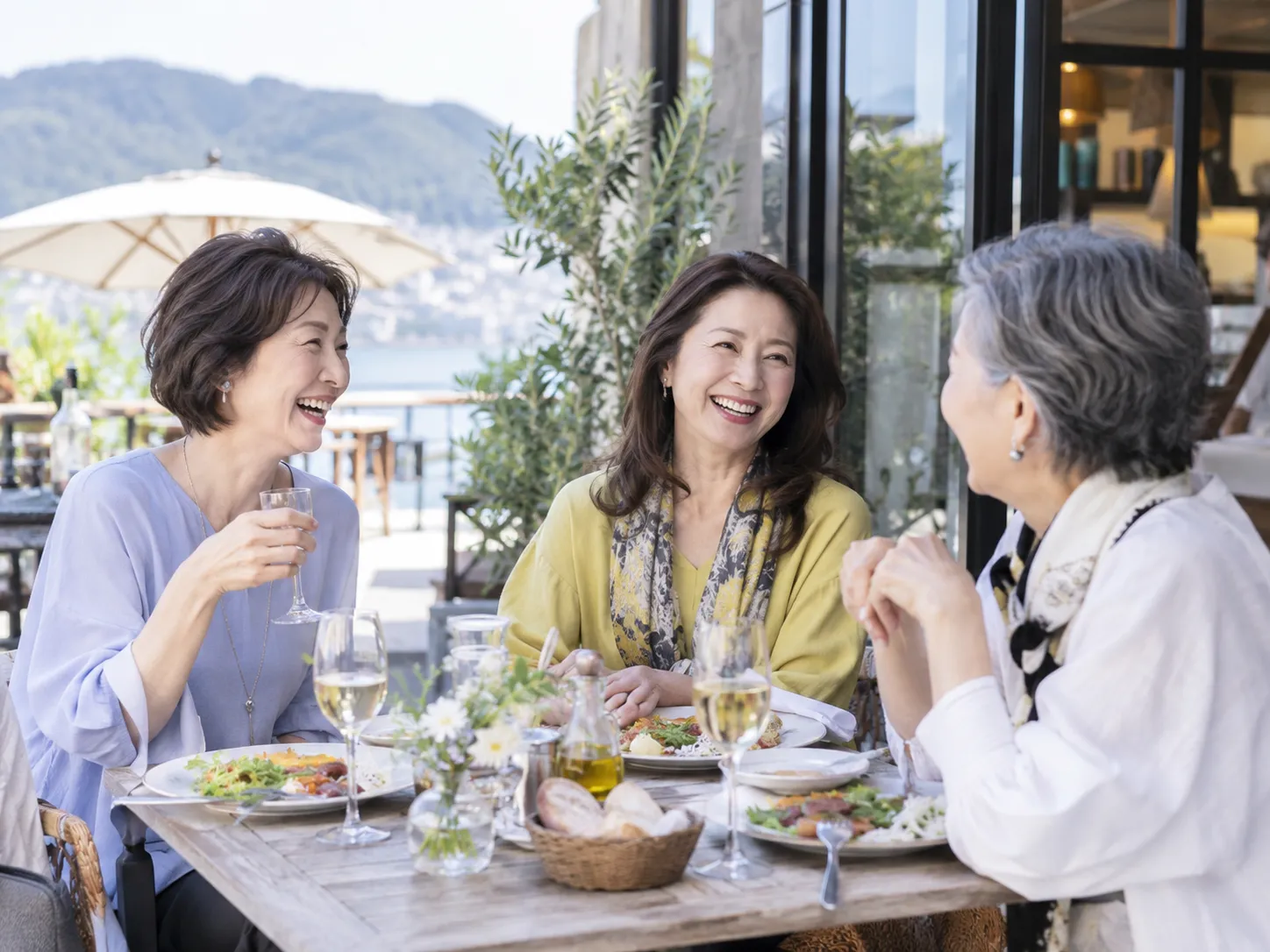 テラスで笑顔で食事を楽しむ女性たち。